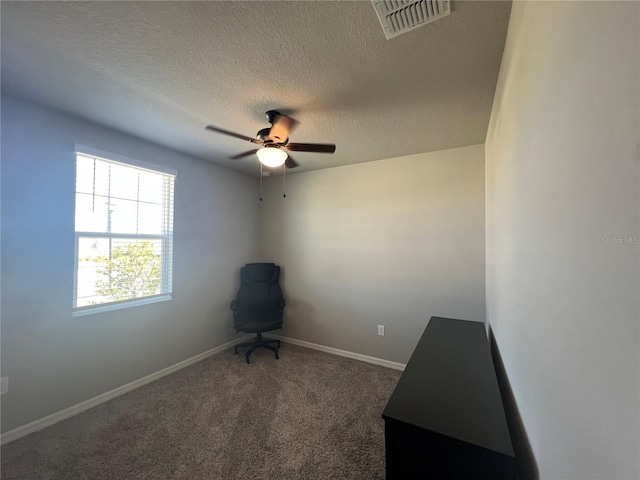 interior space featuring baseboards, visible vents, carpet floors, ceiling fan, and a textured ceiling