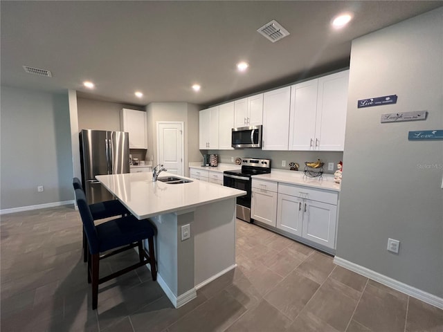 kitchen featuring visible vents, a center island with sink, appliances with stainless steel finishes, and a sink