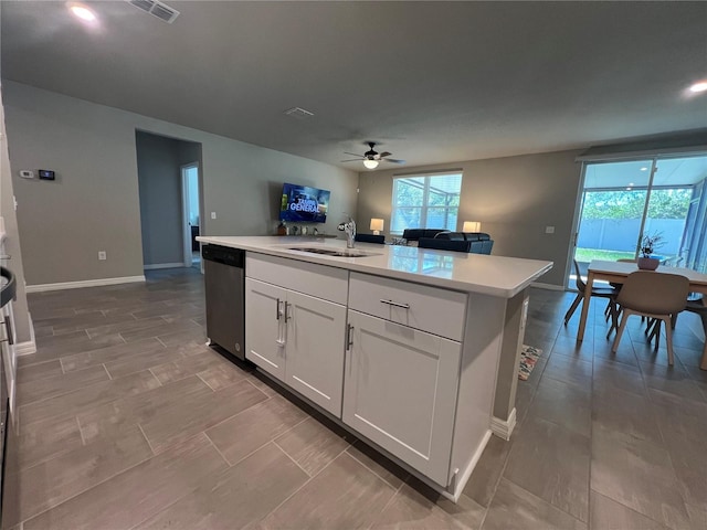 kitchen with a ceiling fan, a sink, stainless steel dishwasher, open floor plan, and light countertops