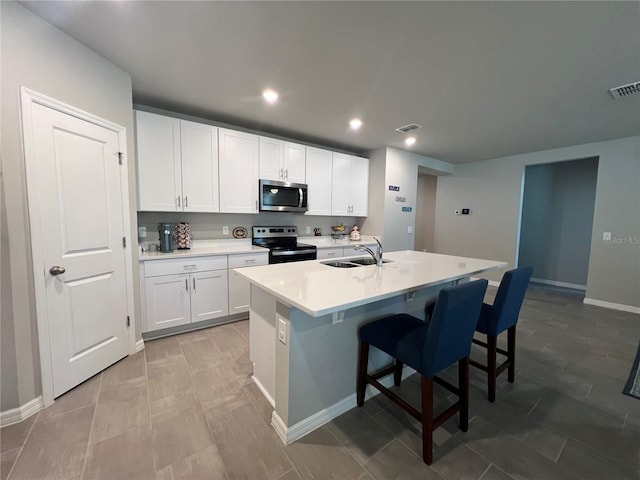 kitchen with a sink, light countertops, white cabinetry, and stainless steel appliances