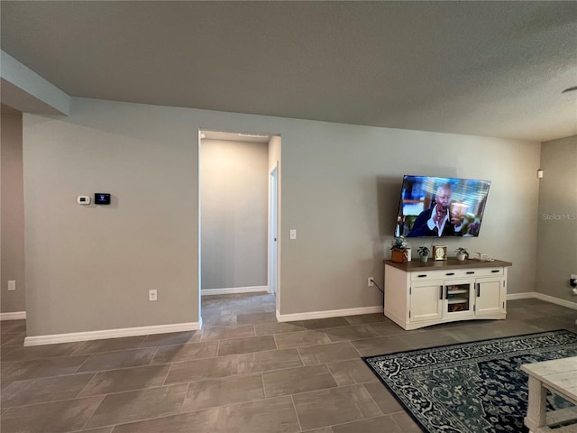 living area featuring baseboards and a textured ceiling