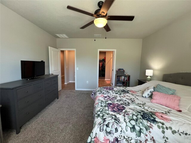 carpeted bedroom featuring baseboards, visible vents, a textured ceiling, and a ceiling fan