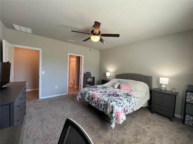 bedroom featuring visible vents, a textured ceiling, carpet floors, baseboards, and ceiling fan