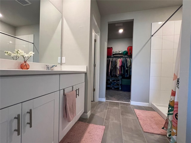 bathroom featuring visible vents, a stall shower, vanity, tile patterned flooring, and a spacious closet