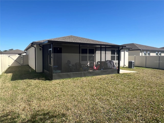 back of house with central AC, stucco siding, a lawn, a fenced backyard, and a sunroom