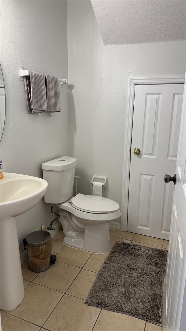10197 Ridgebloom Ave, Orlando, FL 32829 - half bathroom with tile patterned floors, a textured ceiling, and toilet