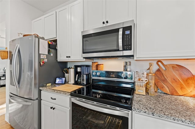 1153 Augustus Dr, Davenport, FL 33896 - kitchen featuring white cabinets, light stone counters, and appliances with stainless steel finishes
