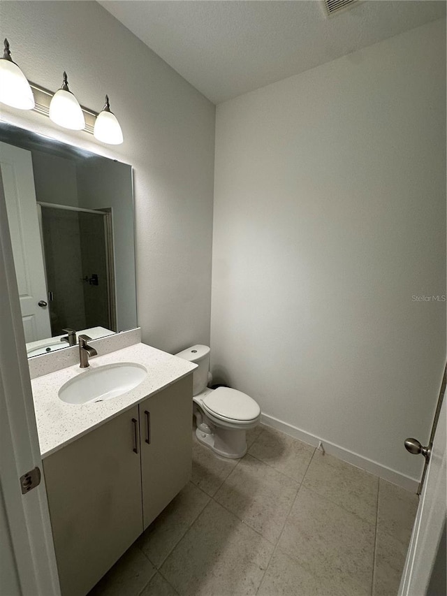 12673 Yoshino Aly, Orlando, FL 32827 - bathroom with baseboards, toilet, a stall shower, tile patterned floors, and vanity