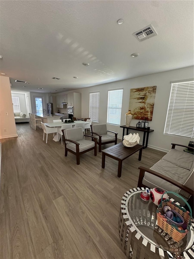 12673 Yoshino Aly, Orlando, FL 32827 - living room with visible vents, baseboards, a textured ceiling, and wood finished floors