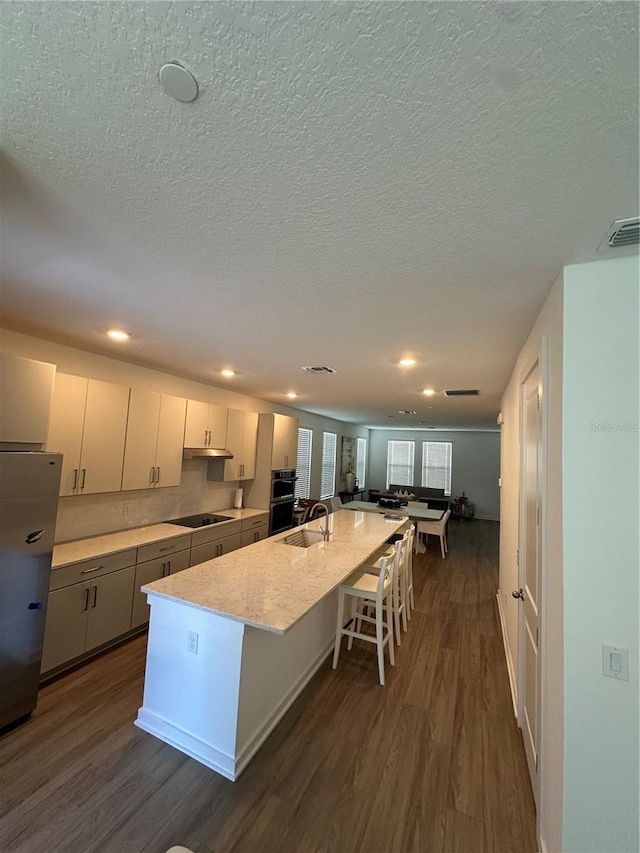 12673 Yoshino Aly, Orlando, FL 32827 - kitchen with dark wood-style floors, visible vents, stainless steel refrigerator, and a sink