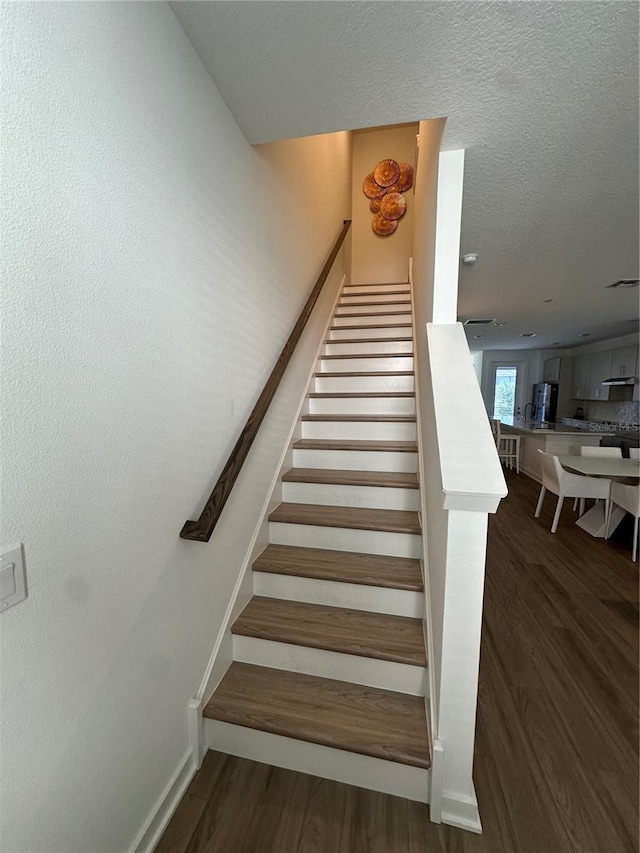 12673 Yoshino Aly, Orlando, FL 32827 - stairway featuring wood finished floors and a textured ceiling