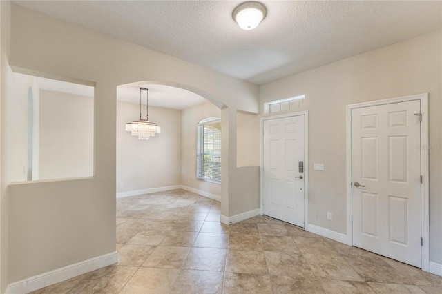 30439 Gidran Ter, Mount Dora, FL 32757 - entrance foyer with arched walkways, baseboards, a chandelier, and a textured ceiling
