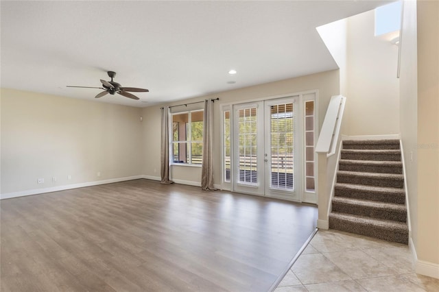 30439 Gidran Ter, Mount Dora, FL 32757 - unfurnished living room with stairs, french doors, baseboards, light wood-style floors, and ceiling fan