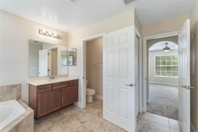 30439 Gidran Ter, Mount Dora, FL 32757 - full bathroom featuring toilet, vanity, a garden tub, a textured ceiling, and ceiling fan