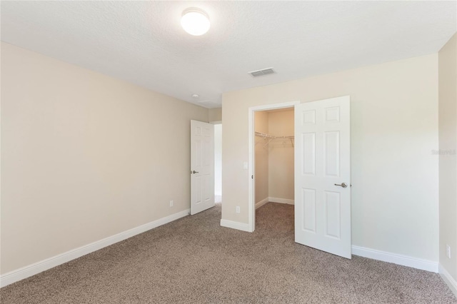30439 Gidran Ter, Mount Dora, FL 32757 - unfurnished bedroom with a walk in closet, baseboards, light colored carpet, and visible vents