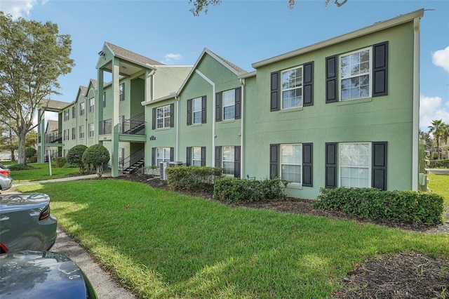 view of property featuring stucco siding and a front lawn