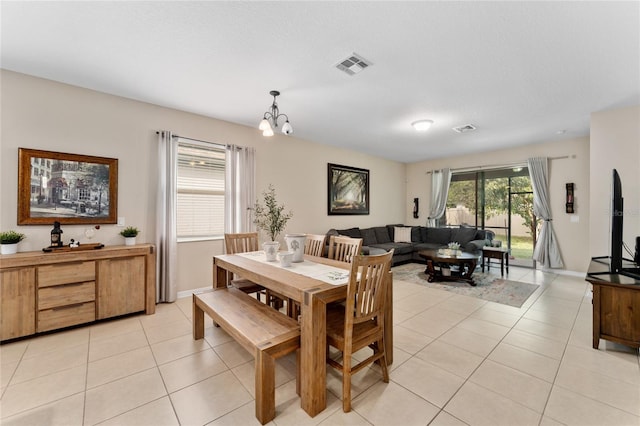 dining space featuring light tile patterned flooring, visible vents, and a chandelier