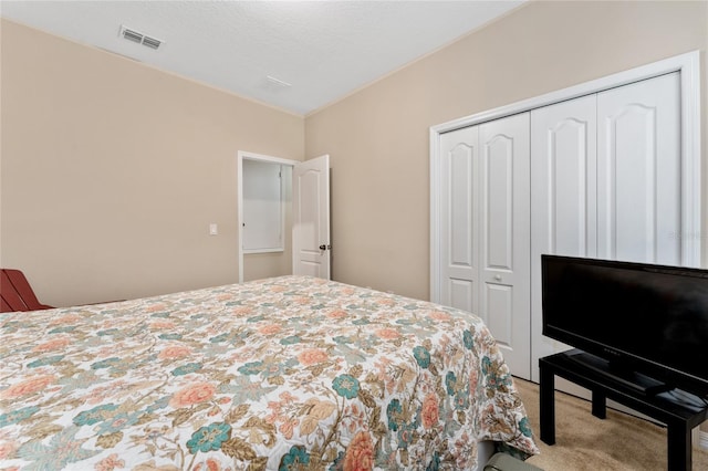 bedroom with a closet, visible vents, a textured ceiling, and carpet floors