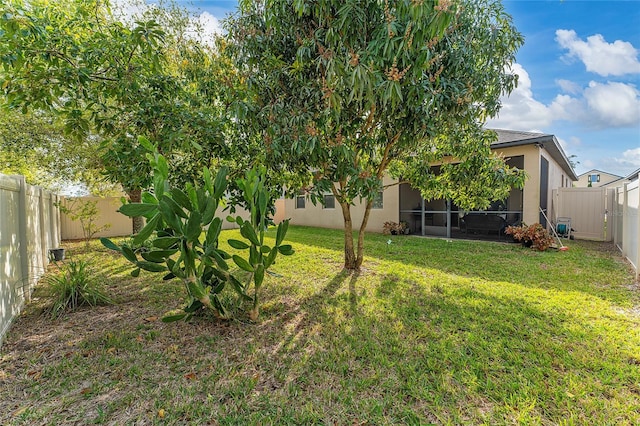 view of yard featuring a fenced backyard and a sunroom