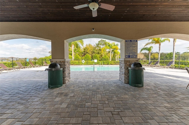 exterior space featuring a ceiling fan, a community pool, and fence
