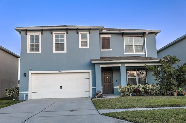 traditional-style home with stucco siding, driveway, a garage, and a front yard