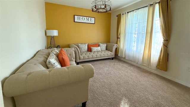 living room featuring baseboards, carpet flooring, and an inviting chandelier