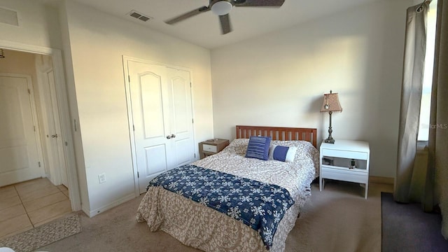 carpeted bedroom featuring ceiling fan, visible vents, and tile patterned flooring