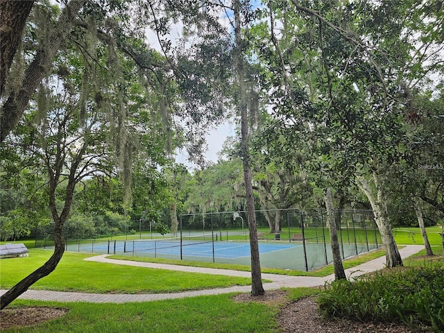 2921 Puerta Del Sol Blvd, Kissimmee, FL 34744 - view of tennis court featuring a lawn and fence