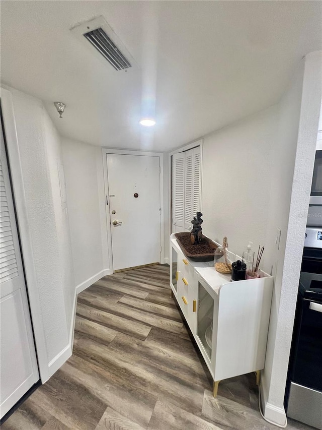 interior space featuring wood finished floors, baseboards, and visible vents