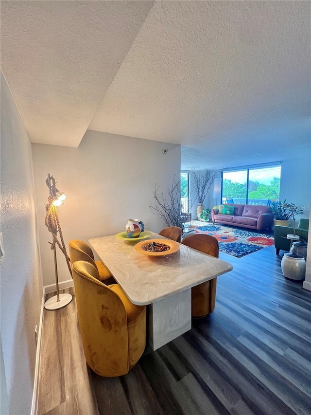 dining area with baseboards, wood finished floors, and a textured ceiling