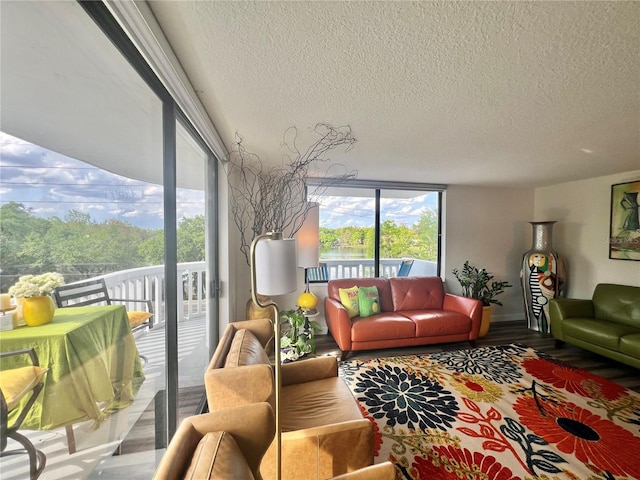 living room with a textured ceiling, baseboards, and wood finished floors