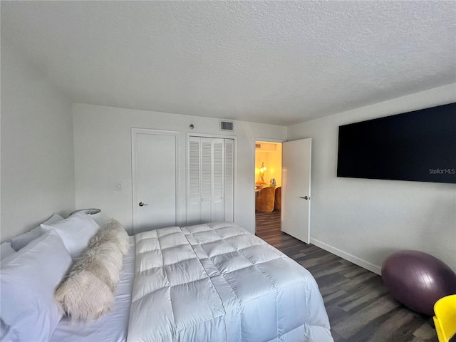 bedroom with a textured ceiling, a closet, visible vents, wood finished floors, and baseboards