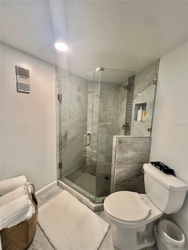 full bathroom featuring visible vents, toilet, a shower stall, and baseboards