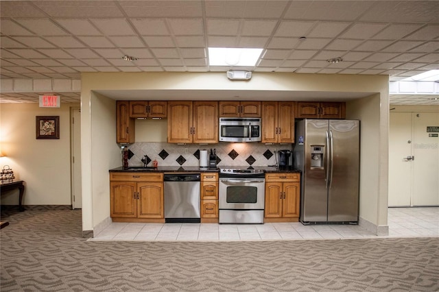 kitchen featuring brown cabinetry, light colored carpet, and stainless steel appliances