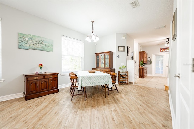 dining area with baseboards, visible vents, light wood-style flooring, and ceiling fan with notable chandelier