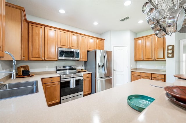 kitchen with a sink, appliances with stainless steel finishes, recessed lighting, and visible vents
