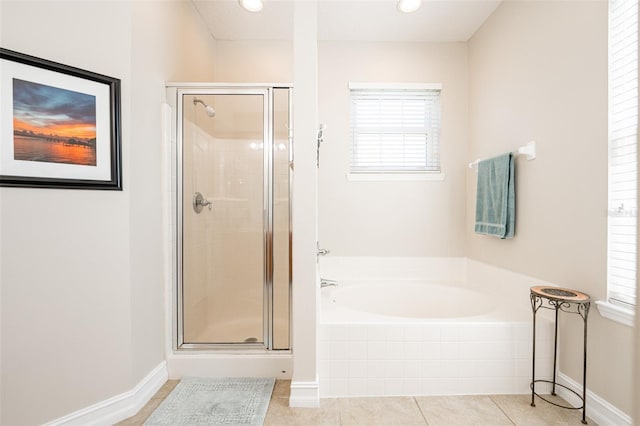 bathroom featuring a bath, baseboards, tile patterned flooring, and a shower stall