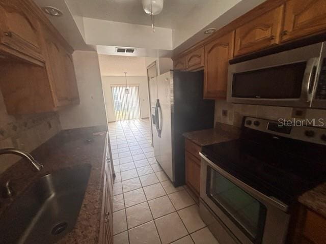kitchen featuring appliances with stainless steel finishes, decorative backsplash, a sink, and visible vents