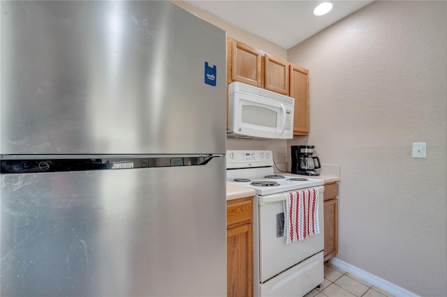 4561 Yellowgold Rd E Unit 107, Kissimmee, FL 34746 - kitchen featuring white appliances, light countertops, baseboards, and light tile patterned floors