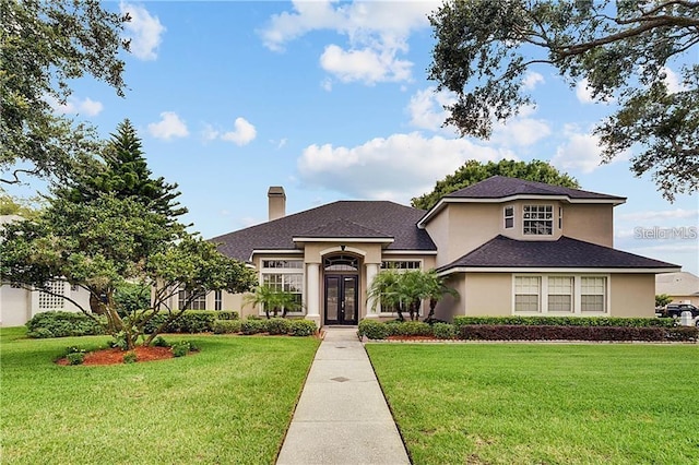 3637 Rothbury Dr, Belle Isle, FL 32812 - view of front of home with french doors, stucco siding, a chimney, and a front lawn