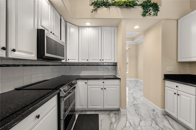 3637 Rothbury Dr, Belle Isle, FL 32812 - kitchen featuring stainless steel electric range, marble finish floor, white cabinetry, baseboards, and backsplash
