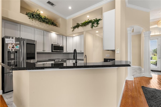 3637 Rothbury Dr, Belle Isle, FL 32812 - kitchen with stainless steel appliances, arched walkways, decorative columns, and ornamental molding