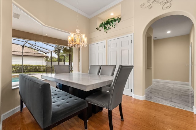 3637 Rothbury Dr, Belle Isle, FL 32812 - dining space with arched walkways, a chandelier, baseboards, visible vents, and ornamental molding