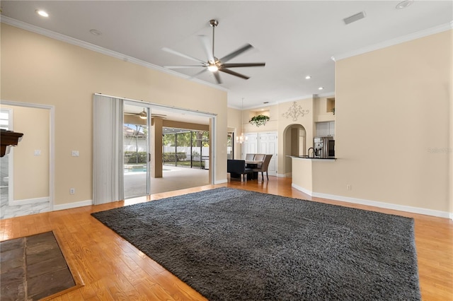3637 Rothbury Dr, Belle Isle, FL 32812 - living area with ceiling fan, light wood-style floors, arched walkways, visible vents, and ornamental molding