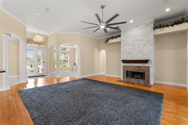 3637 Rothbury Dr, Belle Isle, FL 32812 - unfurnished living room featuring a ceiling fan, a fireplace, ornamental molding, ornate columns, and light wood-style flooring