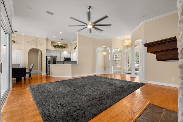 3637 Rothbury Dr, Belle Isle, FL 32812 - living room with crown molding, arched walkways, ceiling fan, and decorative columns