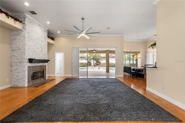 3637 Rothbury Dr, Belle Isle, FL 32812 - unfurnished living room with visible vents, crown molding, wood finished floors, a stone fireplace, and a ceiling fan
