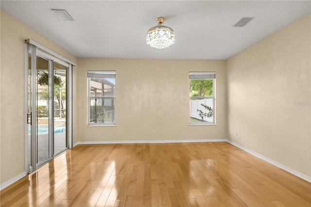 3637 Rothbury Dr, Belle Isle, FL 32812 - empty room featuring baseboards, light wood finished floors, and a chandelier