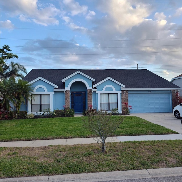 12966 Broakfield Cir, Orlando, FL 32837 - ranch-style house featuring stucco siding, driveway, a front lawn, a garage, and a shingled roof