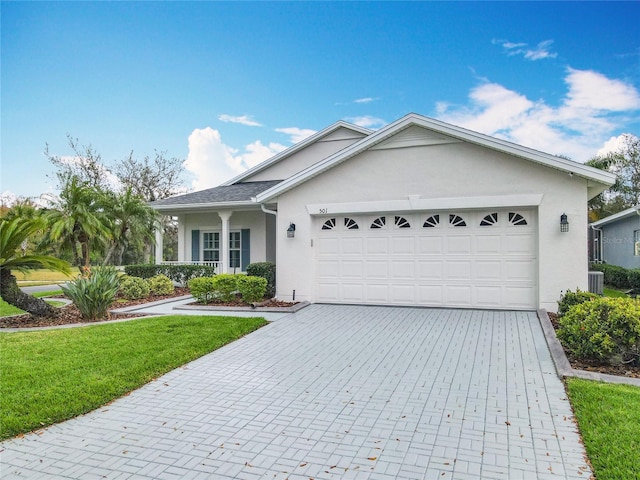 501 Heartwell Dr, Poinciana, FL 34759 - ranch-style home with a front yard, stucco siding, decorative driveway, a garage, and central AC
